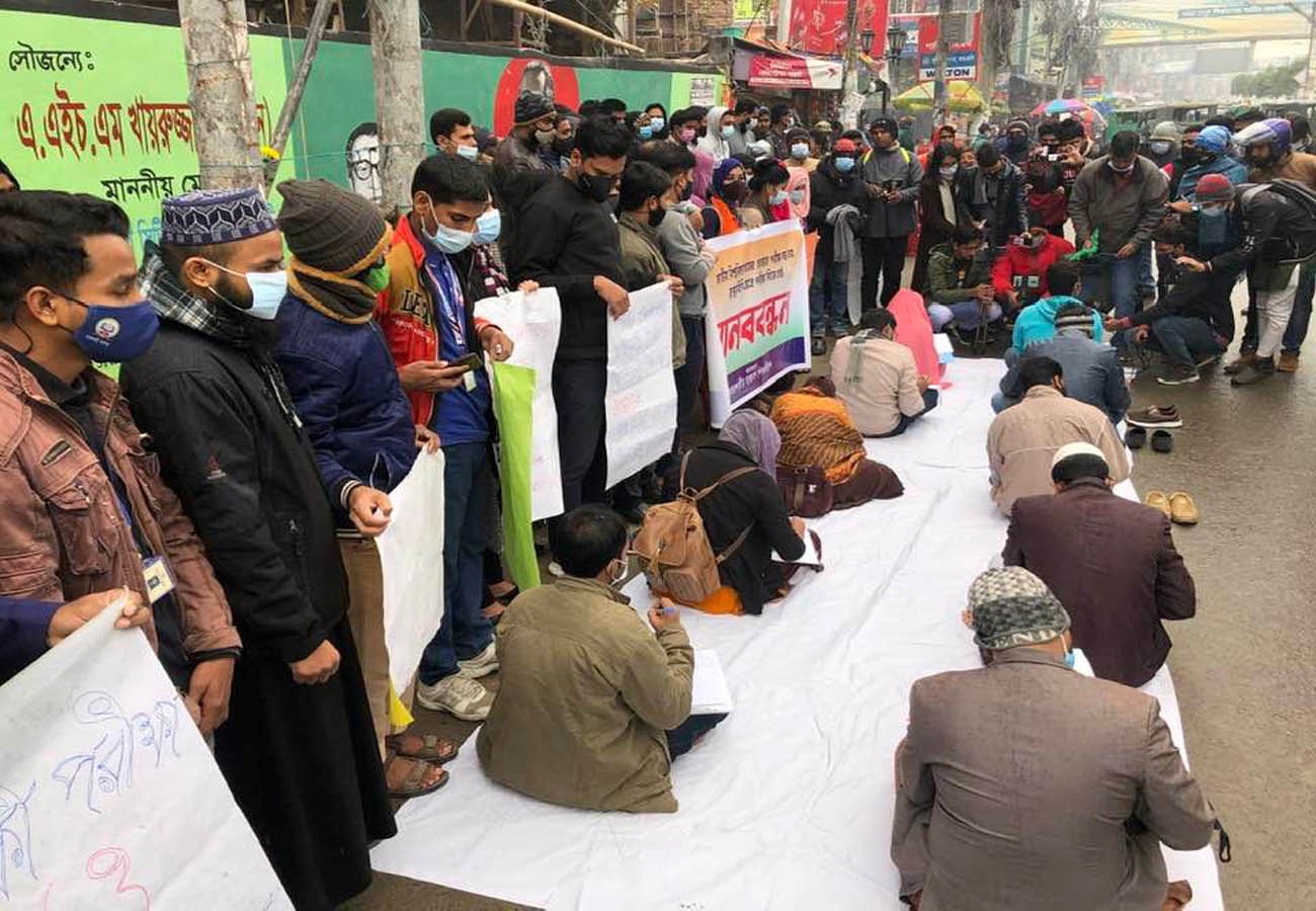 রাজশাহীতে সড়কে প্রতীকী পরীক্ষায় বসেছে জাতীয় বিশ্ববিদ্যালয়ের শিক্ষার্থীরা